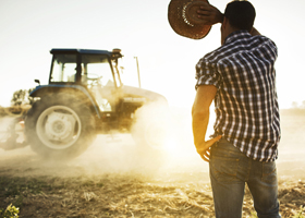 Farmer covers face from sun in a hot day at the fields as tractor passes by. More files of this series and models on port.