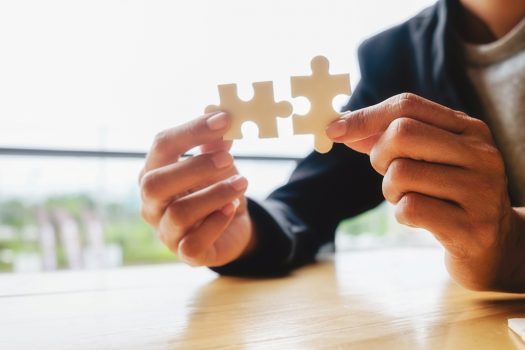 Business woman hands connecting jigsaw puzzle. Business solutions, success and strategy concept. Businessman hand connecting jigsaw puzzle.Close up photo with selective focus.