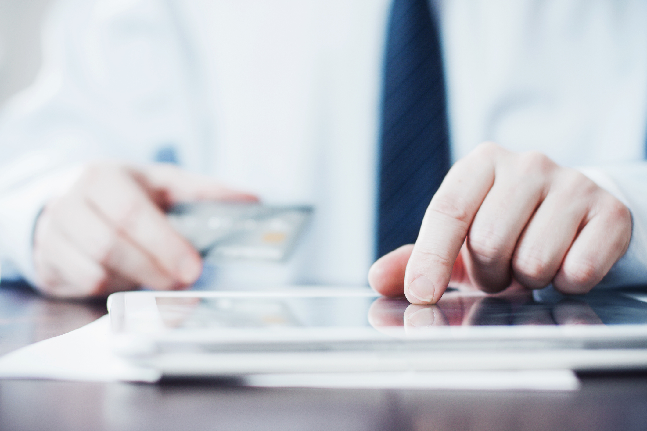 Man Using Tablet and Holding Credit Card.