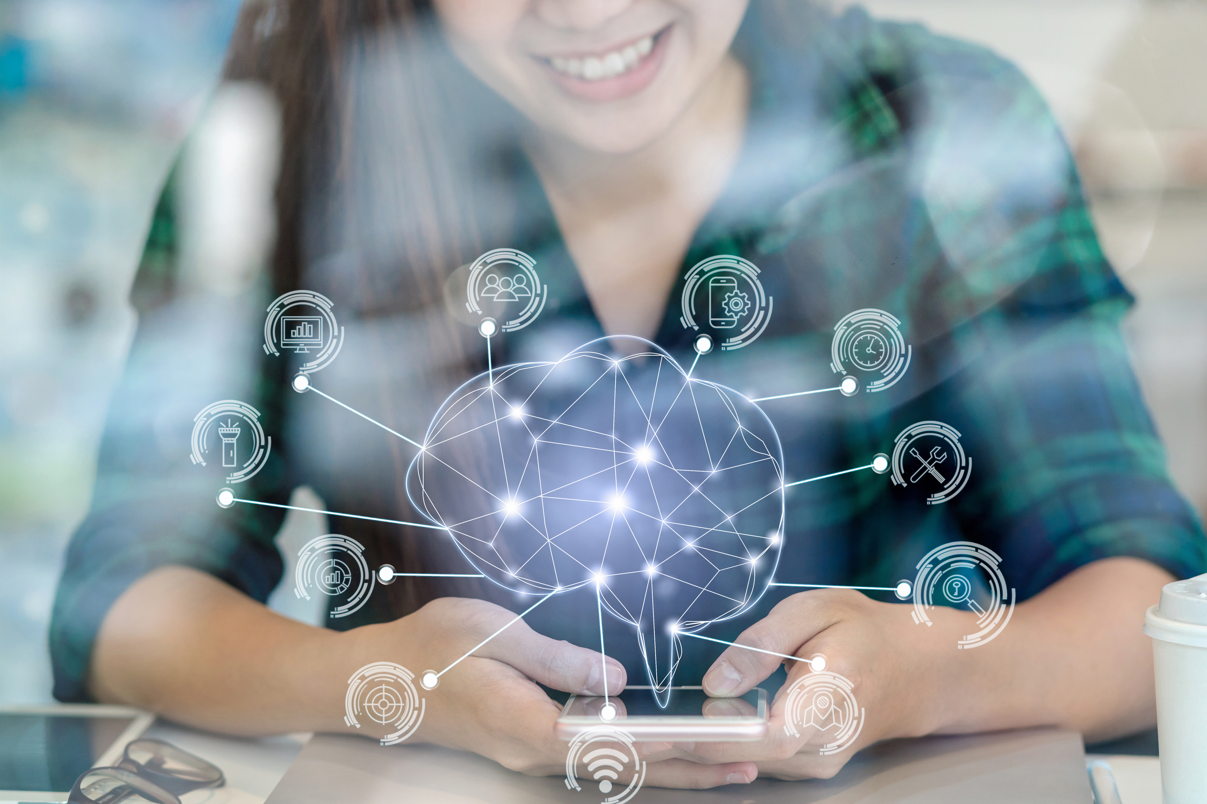 Polygonal brain shape of an artificial intelligence with various icon of smart city Internet of Things Technology over Asian businesswoman hand using the smart mobile phone,AI and business IOT concept, retouch with new product