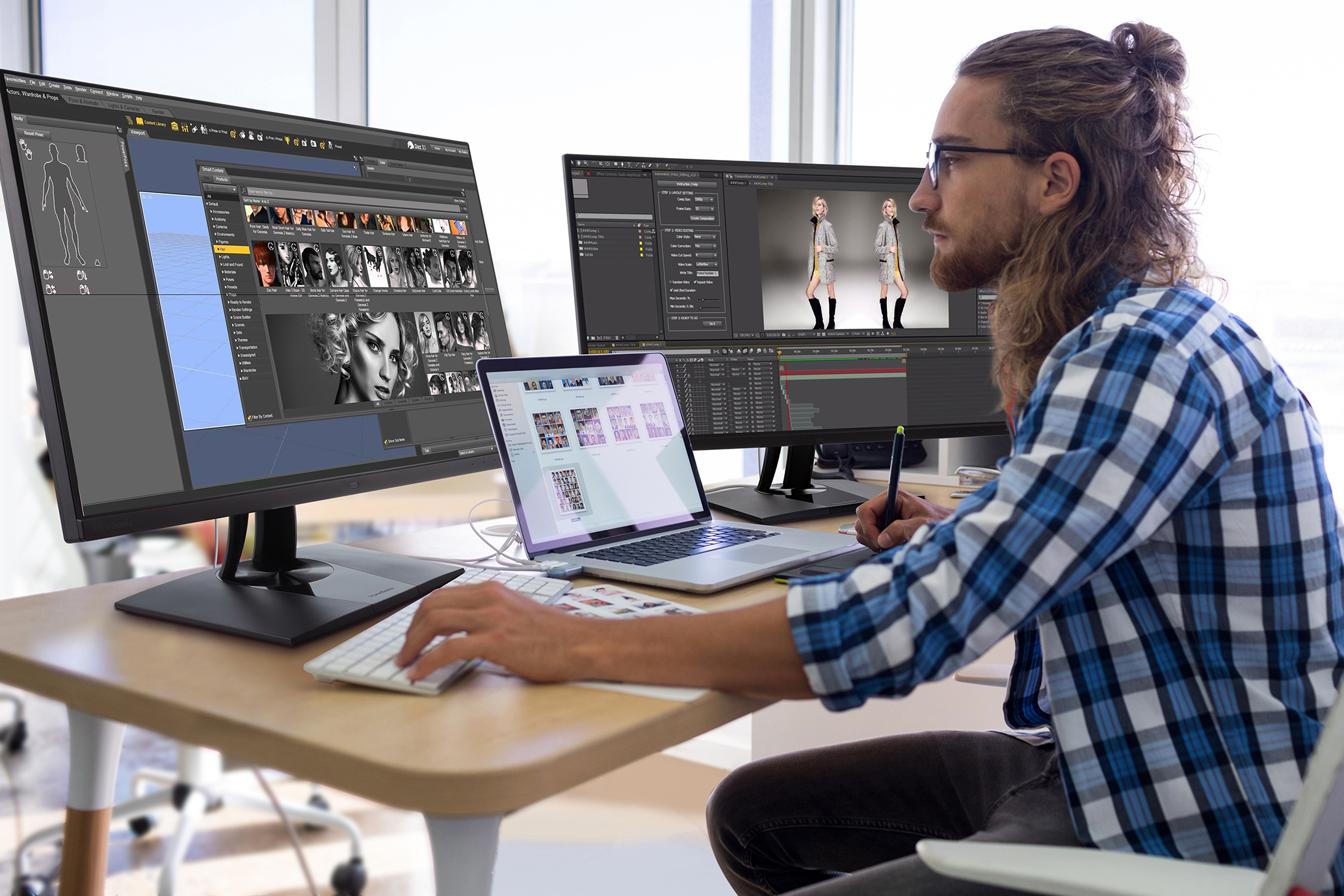 Male executive working over laptop and graphic tablet at his desk