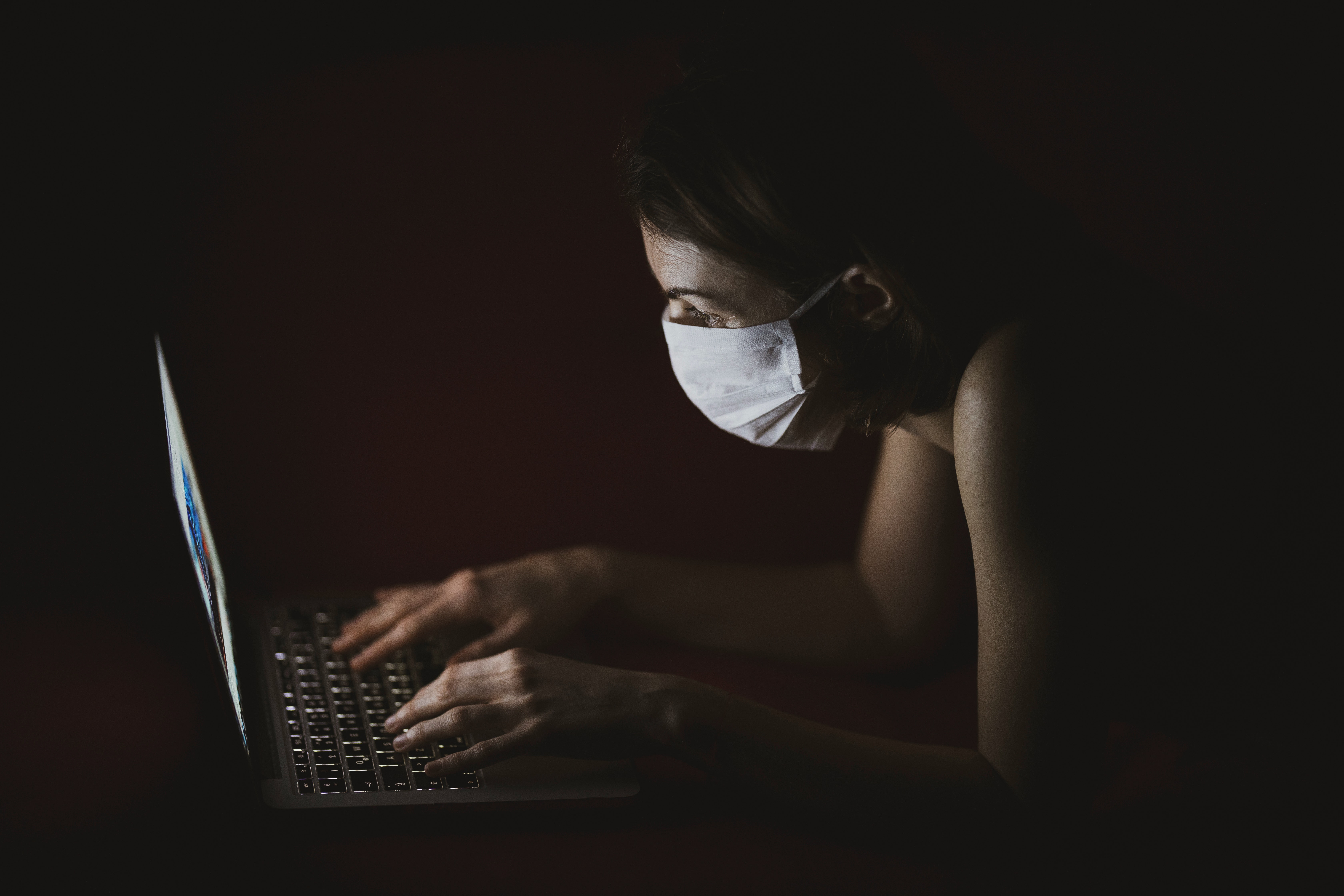 woman-wearing-face-mask-using-macbook-pro-4031902