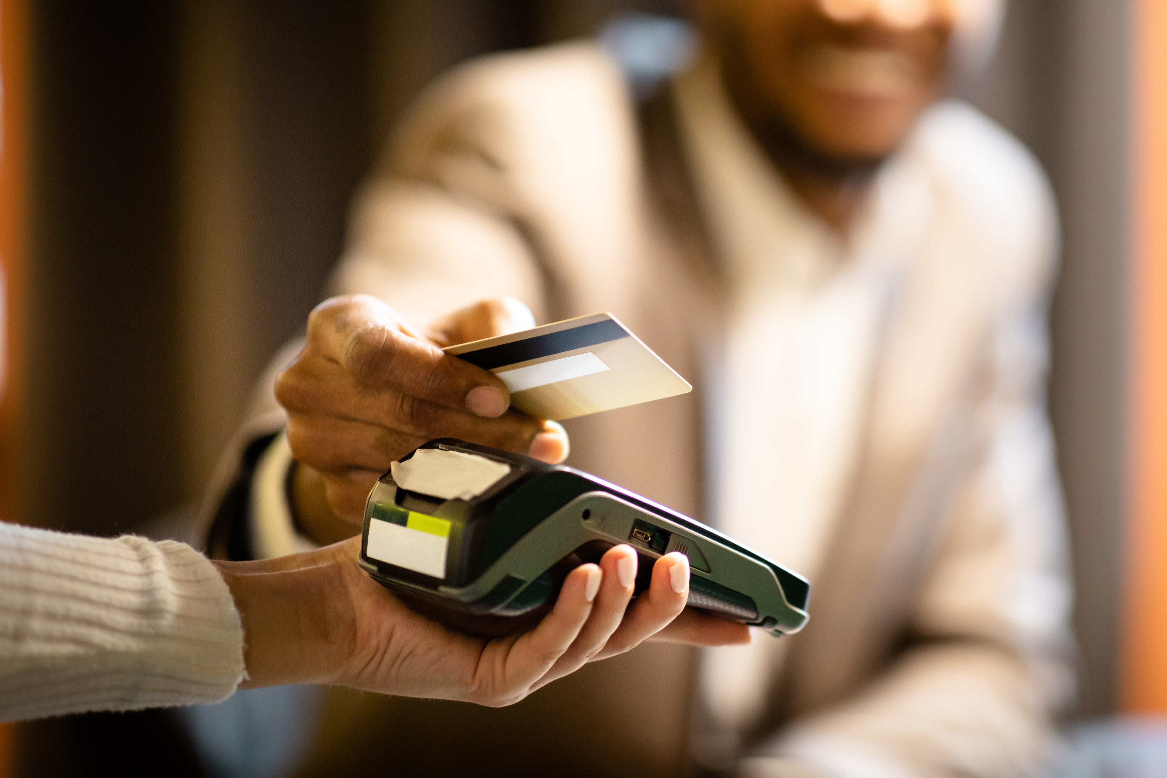 Afro businessman giving credit card to barman