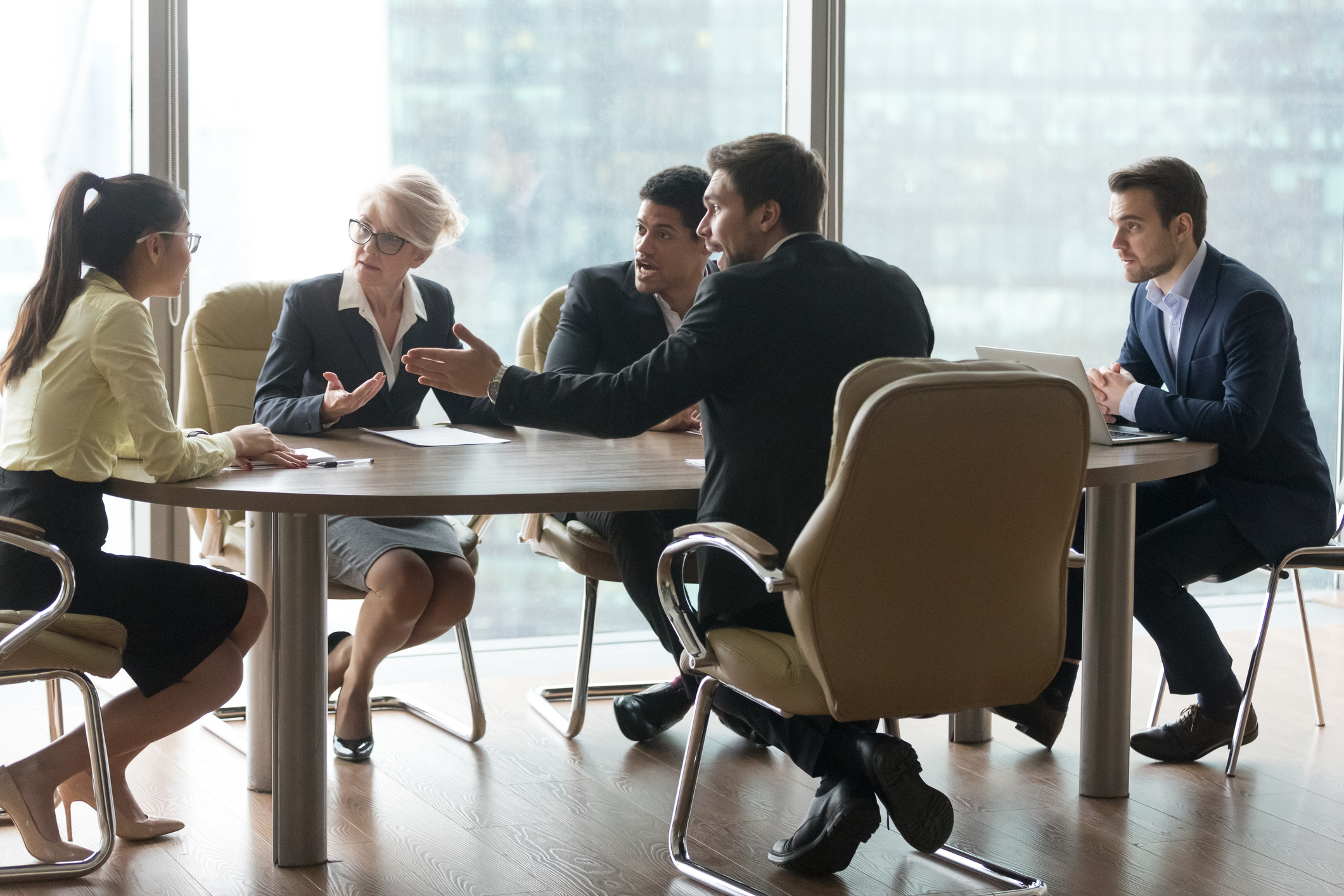 Multiracial team group disputing in office boardroom at meeting