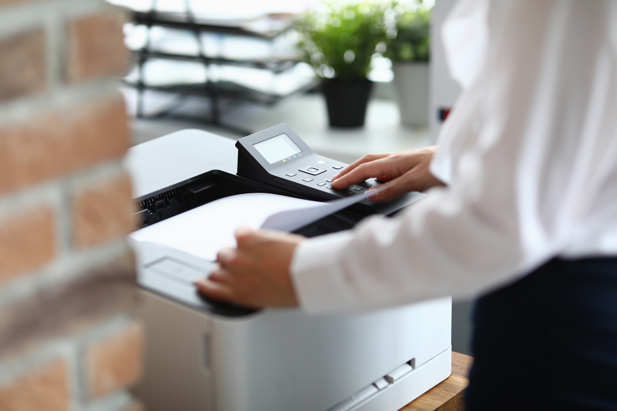 Woman in office prints documents on printer