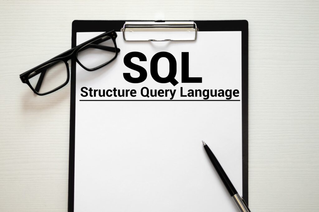 SQL Structured Query Language written in notebook on white table.