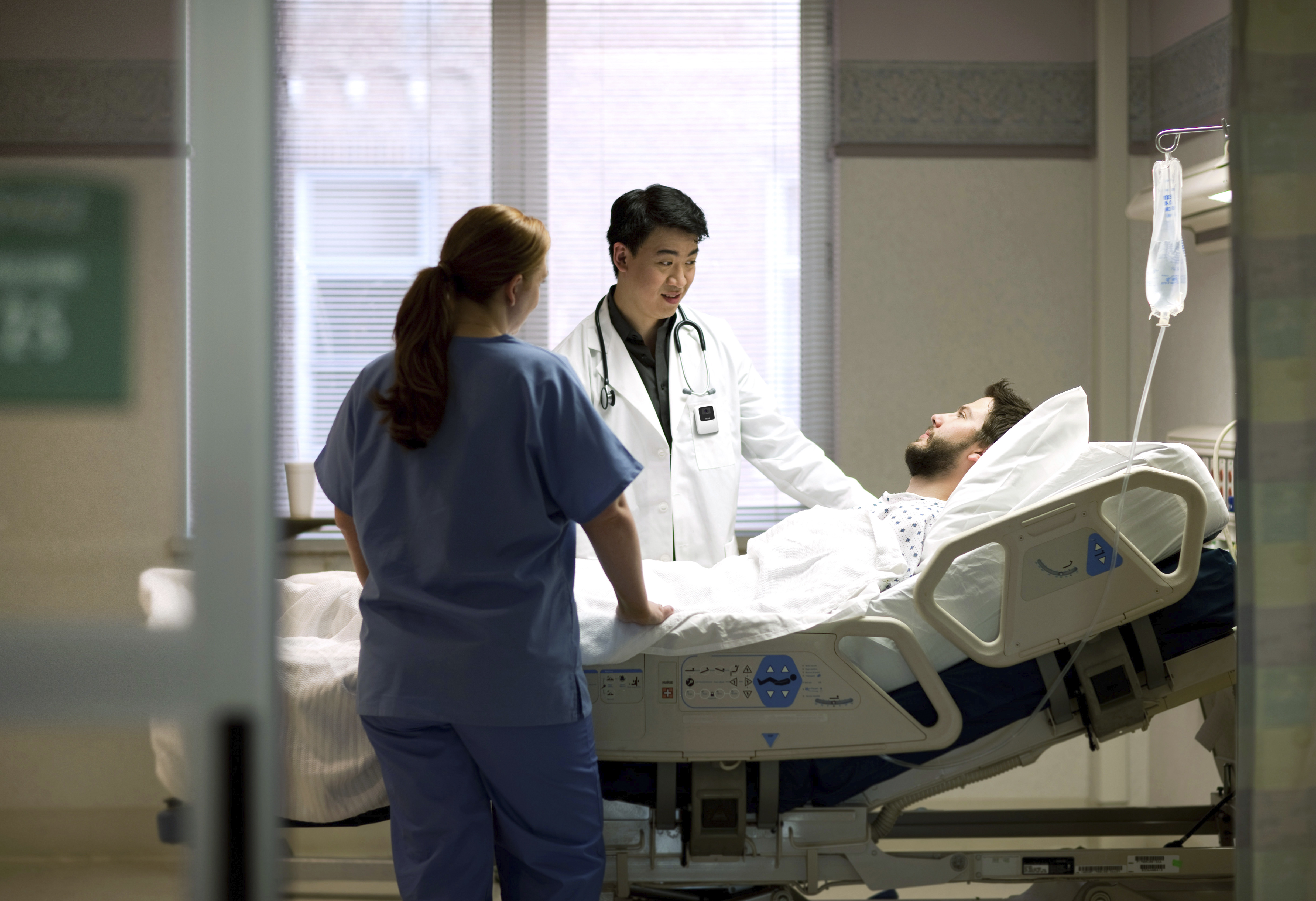Doctor and nurse talking to patient in hospital